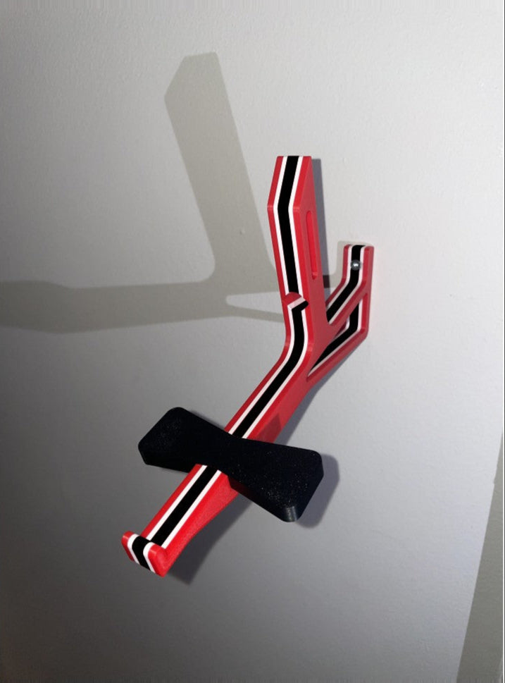 Red, white, and black angled cap butler assembly mounted on a white wall without  a cap