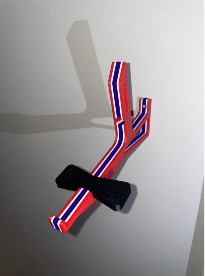 Red, white, and blue angled cap butler assembly mounted on a white wall without  a cap