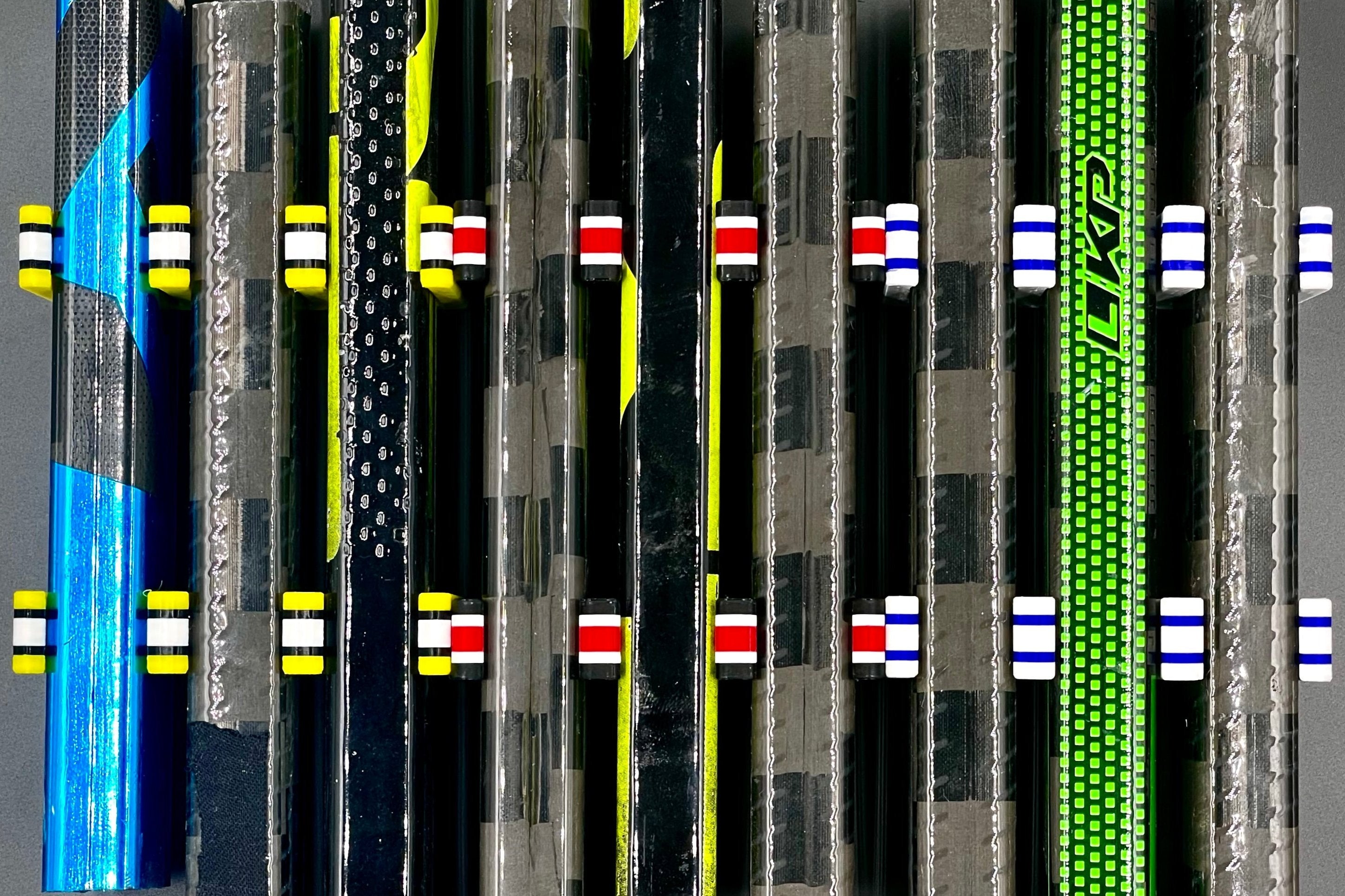 Three sets of Stick Em Ups of various colorways holding sticks vertically next to one another