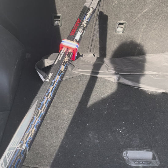 Easily loading clipped hockey sticks into a car's trunk